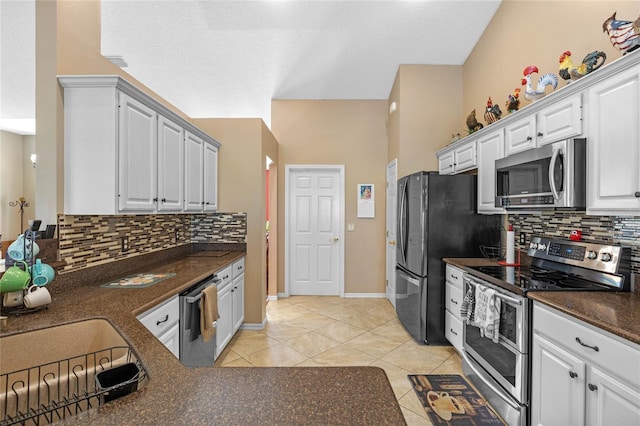 kitchen with white cabinetry, light tile patterned floors, backsplash, and stainless steel appliances