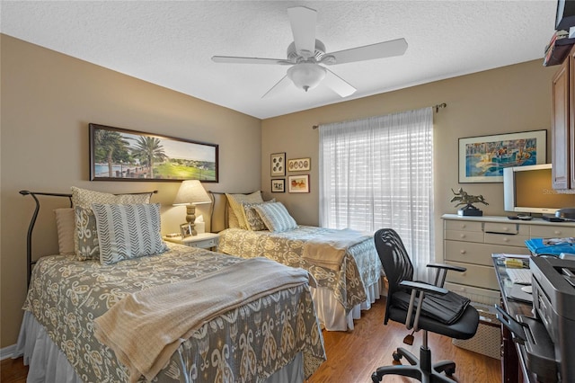 bedroom featuring ceiling fan, light hardwood / wood-style flooring, and a textured ceiling