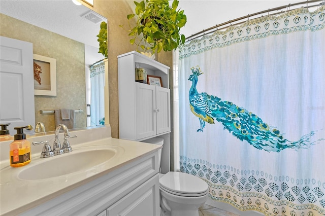 bathroom featuring vanity, tile patterned flooring, toilet, and walk in shower