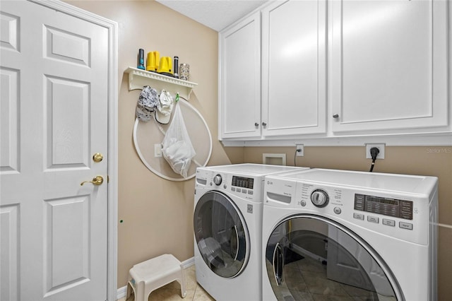 laundry area featuring cabinets, tile patterned floors, and washer and clothes dryer