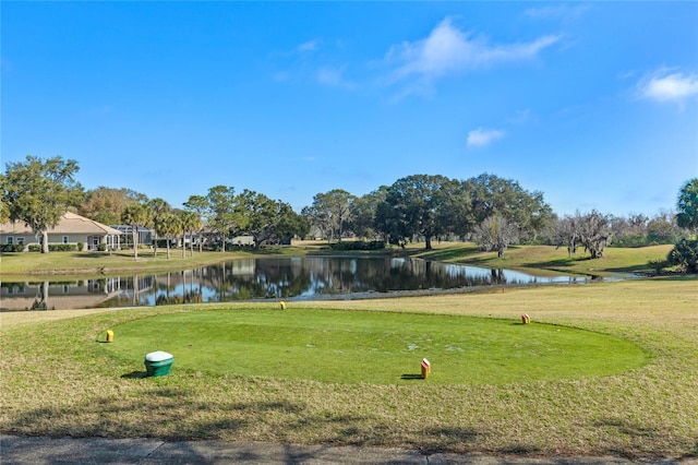 view of home's community with a water view and a lawn