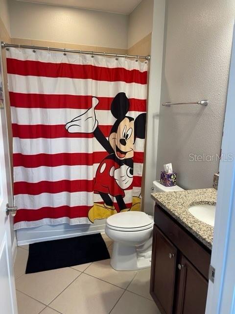 294 Captiva Dr, Davenport, FL 33896 - bathroom featuring toilet, vanity, tile patterned floors, and a shower with curtain