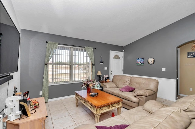 tiled living room with lofted ceiling and a textured ceiling