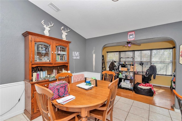 dining area featuring ceiling fan, lofted ceiling, and light tile patterned floors