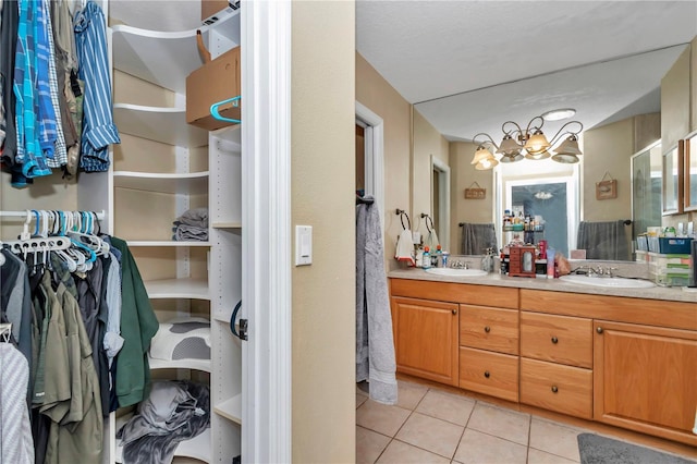 bathroom featuring tile patterned floors, vanity, and a notable chandelier