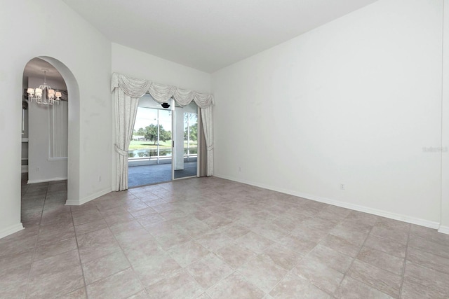 unfurnished room featuring a chandelier