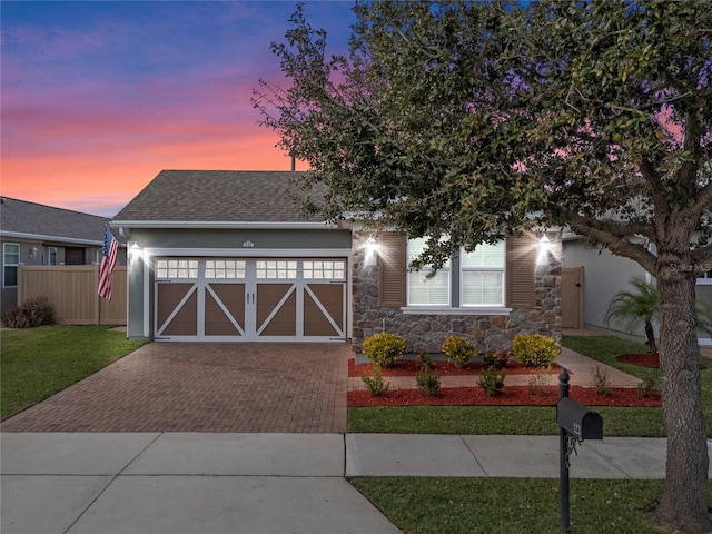 view of front of home featuring a garage and a lawn