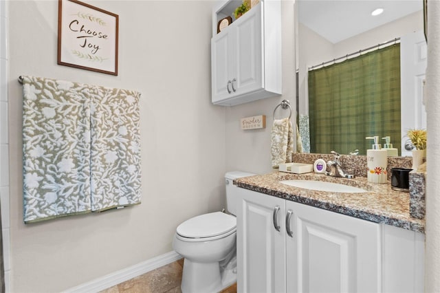 bathroom with tile patterned flooring, vanity, and toilet