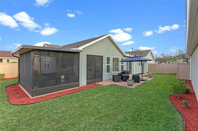 back of house with a sunroom, a yard, and a patio area