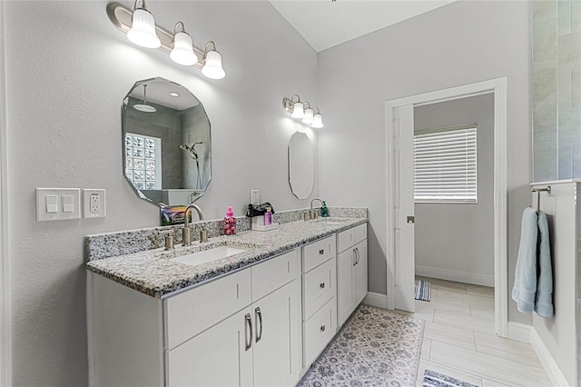 bathroom with walk in shower, vanity, and a wealth of natural light