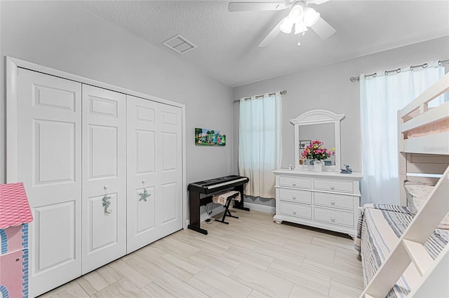 interior space featuring multiple windows, ceiling fan, a closet, and a textured ceiling