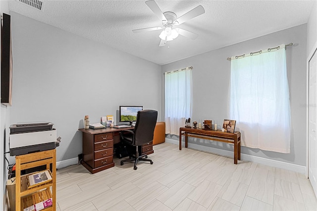 office area with a wealth of natural light, a textured ceiling, and ceiling fan