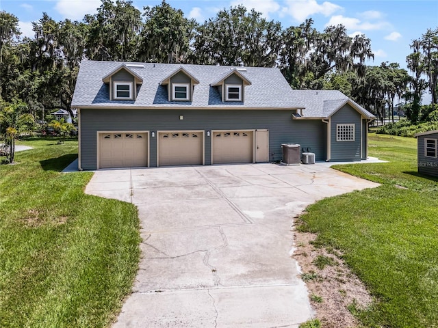 view of front of property with central AC, a garage, and a front lawn