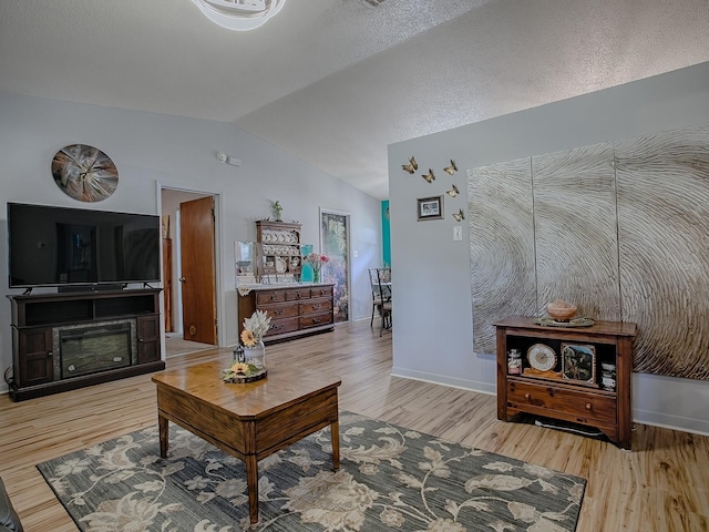 11915 Crk 680, Webster, FL 33597 - living room with a fireplace, vaulted ceiling, and light hardwood / wood-style flooring