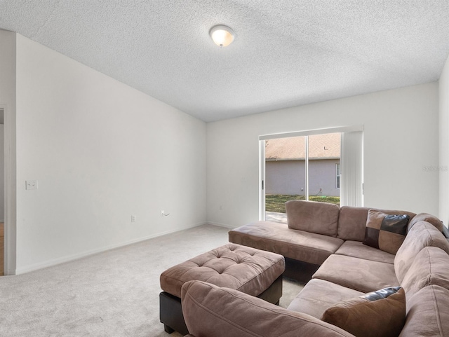 living area featuring light carpet, a textured ceiling, and baseboards