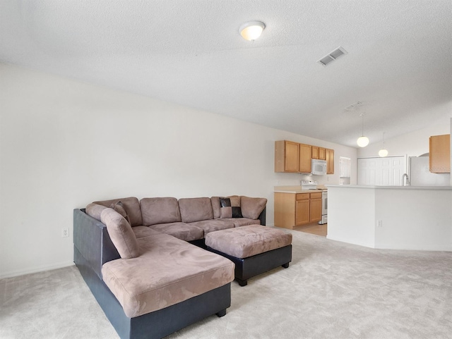 living room featuring lofted ceiling, visible vents, light carpet, and a textured ceiling