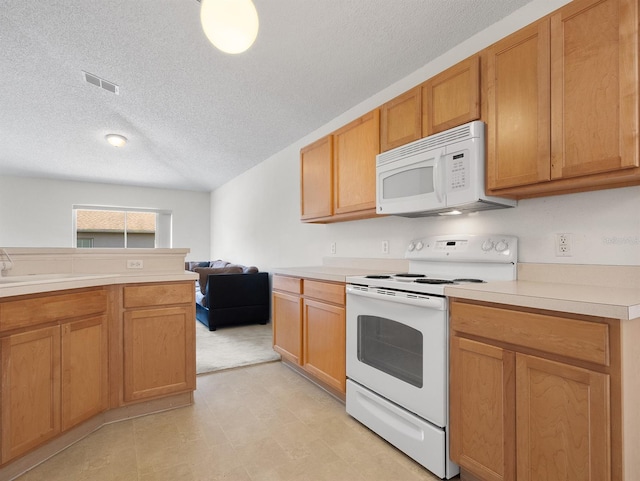 kitchen featuring light countertops, visible vents, a sink, a textured ceiling, and white appliances