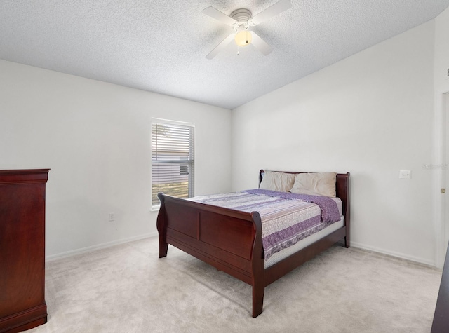 bedroom featuring a ceiling fan, light carpet, a textured ceiling, and baseboards