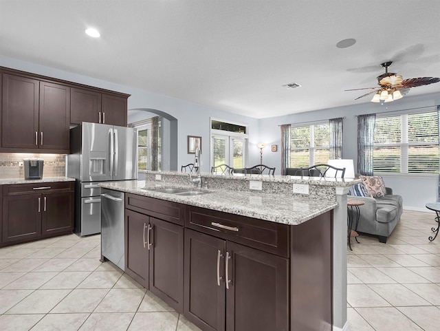 887 Daisy Hill Ct, Apopka, FL 32712 - kitchen featuring appliances with stainless steel finishes, sink, light tile patterned floors, and dark brown cabinets