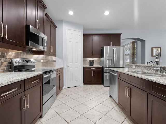 887 Daisy Hill Ct, Apopka, FL 32712 - kitchen featuring sink, dark brown cabinets, light stone countertops, and appliances with stainless steel finishes