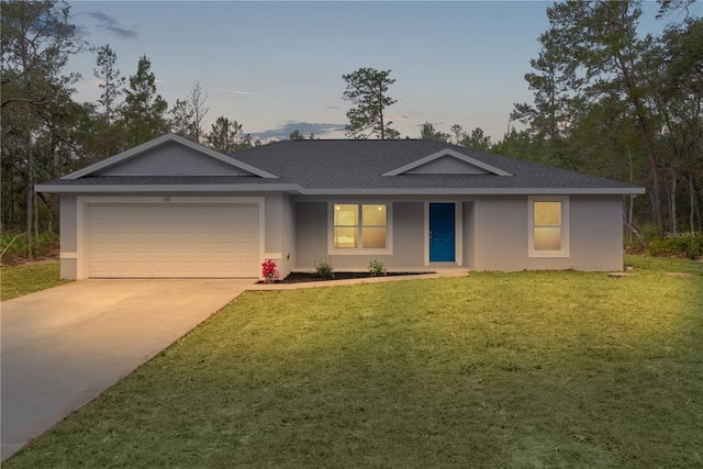 ranch-style house with a garage and a lawn