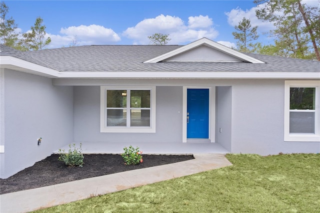 view of exterior entry with a lawn