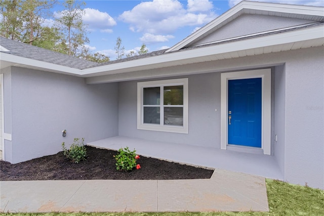 view of exterior entry with a patio area