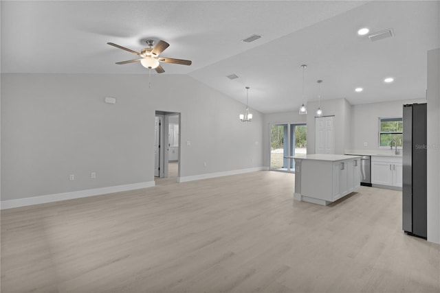 kitchen with a kitchen island, appliances with stainless steel finishes, decorative light fixtures, lofted ceiling, and white cabinets