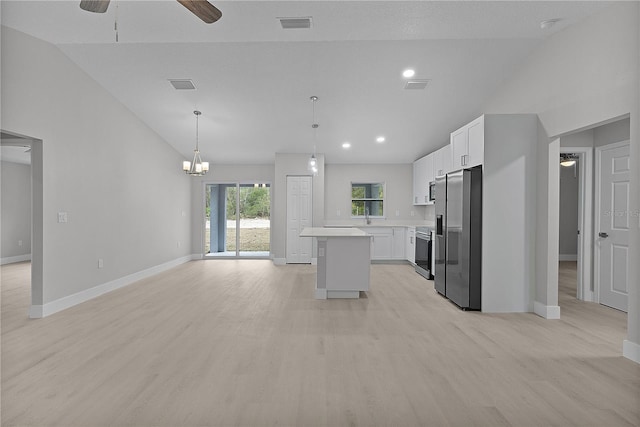 kitchen with vaulted ceiling, appliances with stainless steel finishes, decorative light fixtures, white cabinetry, and a center island