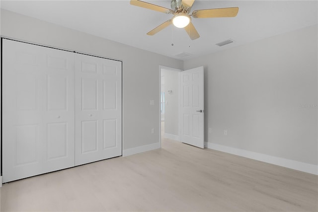 unfurnished bedroom featuring ceiling fan, light wood-type flooring, and a closet