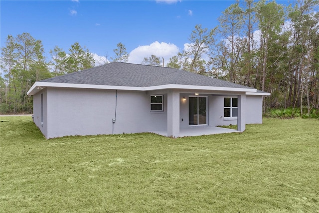 back of property with a lawn and a patio