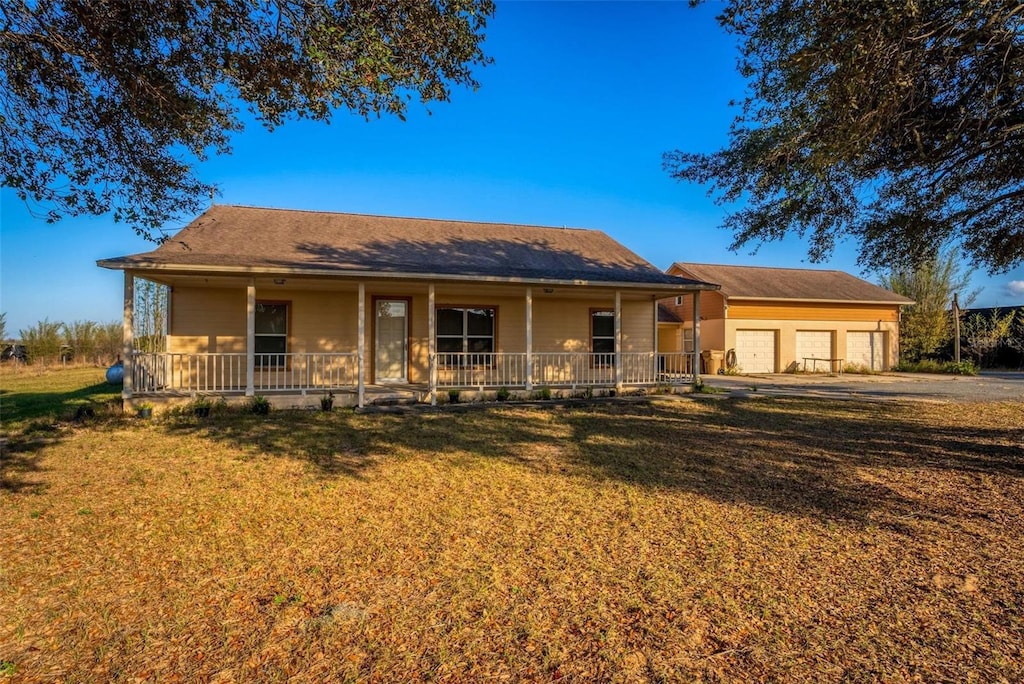 view of front of home featuring a garage, a front lawn, and covered porch