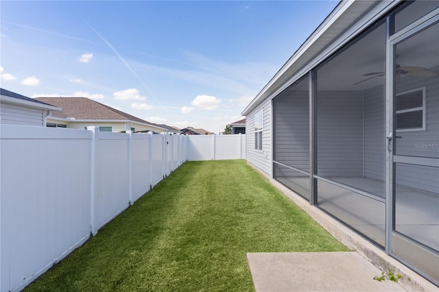 view of yard with a fenced backyard and ceiling fan