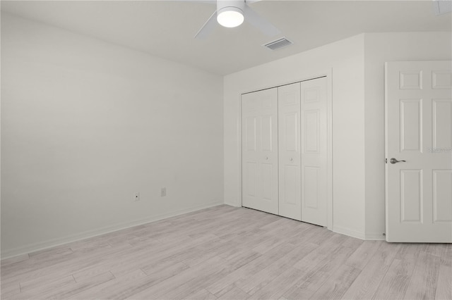 unfurnished bedroom with a closet, visible vents, a ceiling fan, light wood-type flooring, and baseboards