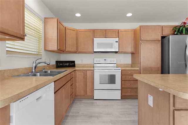 kitchen featuring white appliances, light wood-style flooring, light countertops, a sink, and recessed lighting