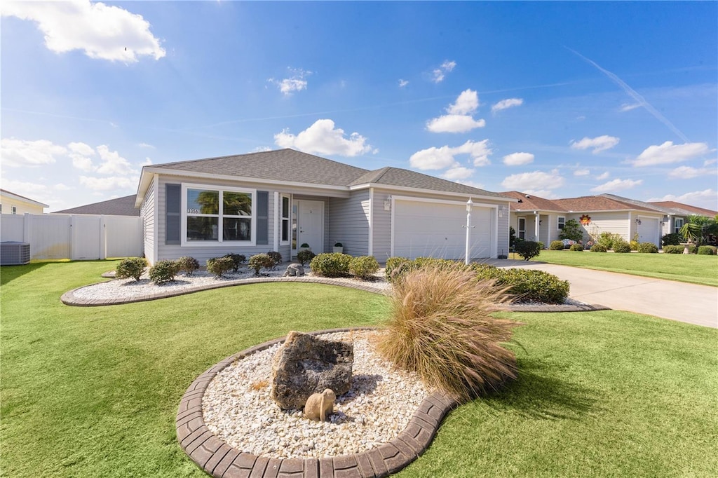 ranch-style house with a front lawn, driveway, an attached garage, and fence