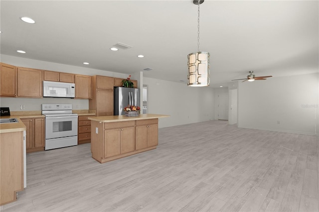 kitchen with a center island, white appliances, light countertops, and hanging light fixtures