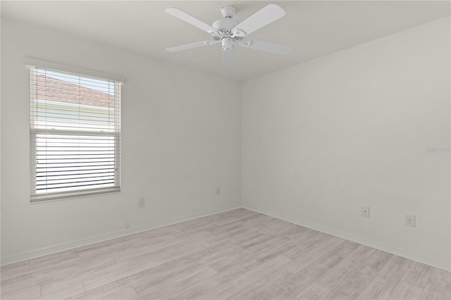 empty room featuring light wood-style floors, baseboards, and a ceiling fan