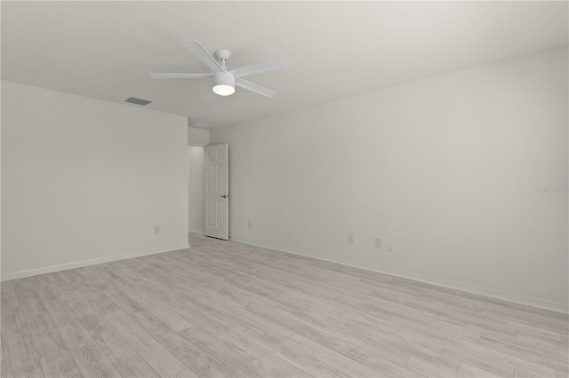 unfurnished room with baseboards, light wood finished floors, visible vents, and a ceiling fan