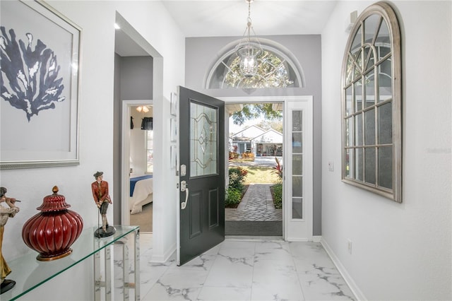 entrance foyer with marble finish floor and baseboards