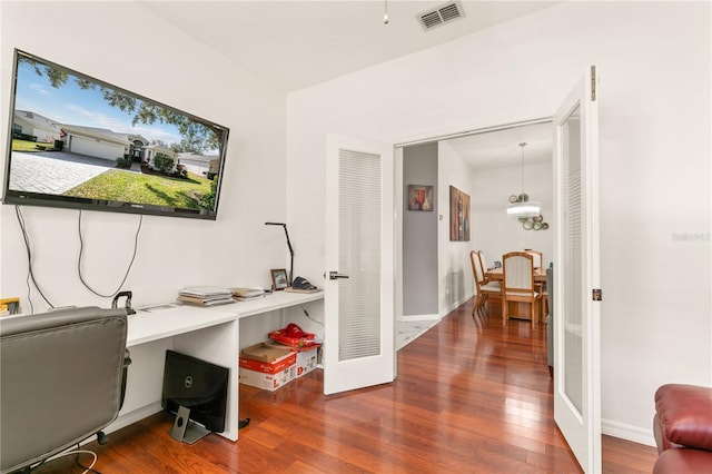 office space with wood finished floors, visible vents, and baseboards