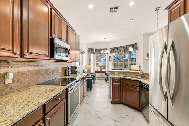 kitchen featuring visible vents, appliances with stainless steel finishes, hanging light fixtures, marble finish floor, and a sink