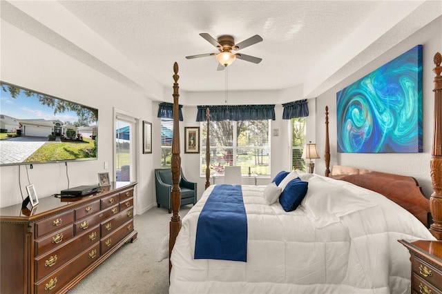 bedroom with light carpet, ceiling fan, and a textured ceiling