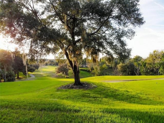 surrounding community featuring a lawn and golf course view