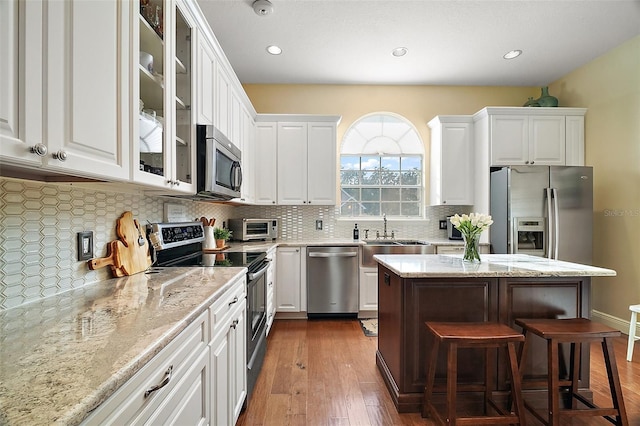 kitchen featuring sink, a breakfast bar area, white cabinetry, a kitchen island, and stainless steel appliances