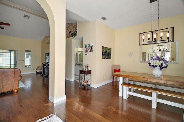 dining space featuring dark hardwood / wood-style floors, ceiling fan with notable chandelier, and high vaulted ceiling