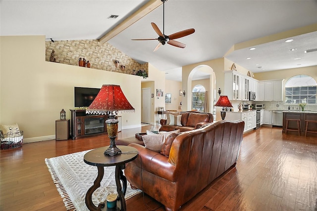 living room featuring ceiling fan, dark hardwood / wood-style flooring, and lofted ceiling with beams