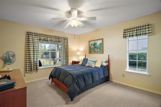 carpeted bedroom with multiple windows, ceiling fan, and a textured ceiling