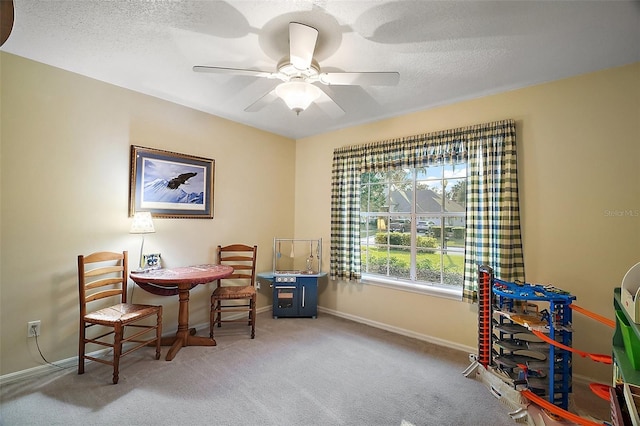 interior space featuring a textured ceiling, ceiling fan, and carpet flooring