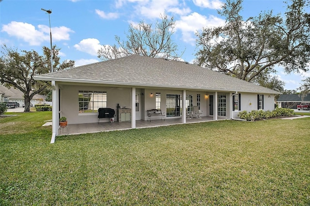 rear view of house featuring a patio area and a lawn